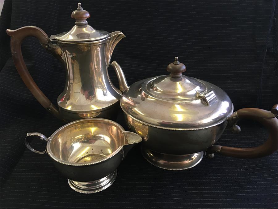 A silver teapot, hot water jug and milk jug. Hallmarked Birmingham 1931 Total weight 865 grms