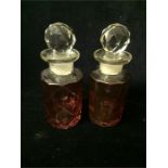 A pair of cranberry glass stoppered bottles