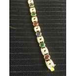 An emerald, ruby, sapphire and diamond flexible link section bracelet all in yellow metal set with
