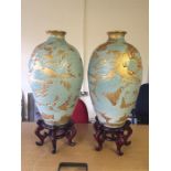 Two large oriental urns on stands. Approximately three foot tall with gold leaf decoration.