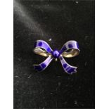 A silver and blue enamel bow shaped brooch