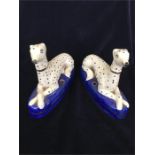 A pair of Staffordshire seated whippets, pen holders.