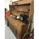 A large antique Pine dresser with three double cupboards below and three display shelves.