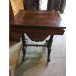 An attractive walnut work table with inlay on ornately carved and ebonised legs ending in pad feet
