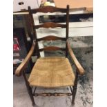 A rattan ladder back elbow chair