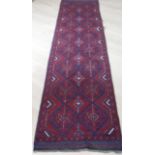 An Afgan hand-knotted Meshwani blue-ground runner with contrasting burgundy and white isometric