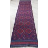An Afgan hand-knotted Meshwani blue-ground runner with multicoloured diamond-shaped decoration and