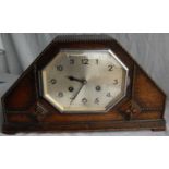 An oak cased 1930s mantle clock with an octagonal silvered dial, Arabic numerals, beaded