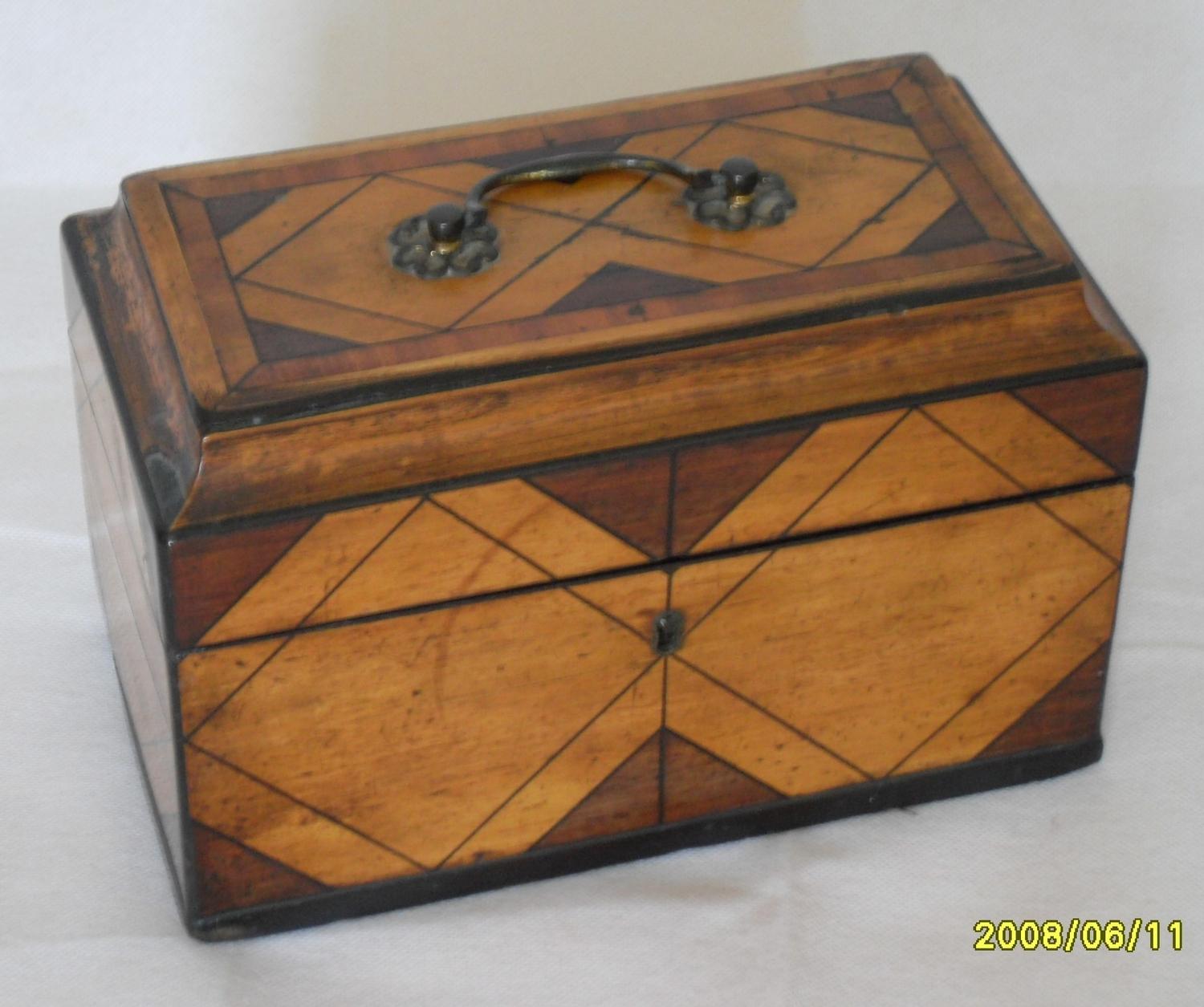 A Regency rectangular tea caddy composed of contrasting mahogany and satinwood with string inlay