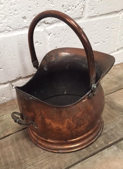 A Victorian copper coal helmet with swing and side handle on a stepped circular foot