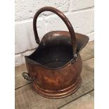 A Victorian copper coal helmet with swing and side handle on a stepped circular foot