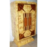 An Art Deco-style walnut veneered drinks cabinet with stepped top, rotating door revealing a
