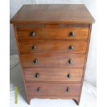 An Edwardian mahogany tall chest of five graduated drawers with turned handles, carved frieze,