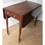 A Regency mahogany Pembroke table with crossbanding to top, twin drop-leaves, frieze drawer with