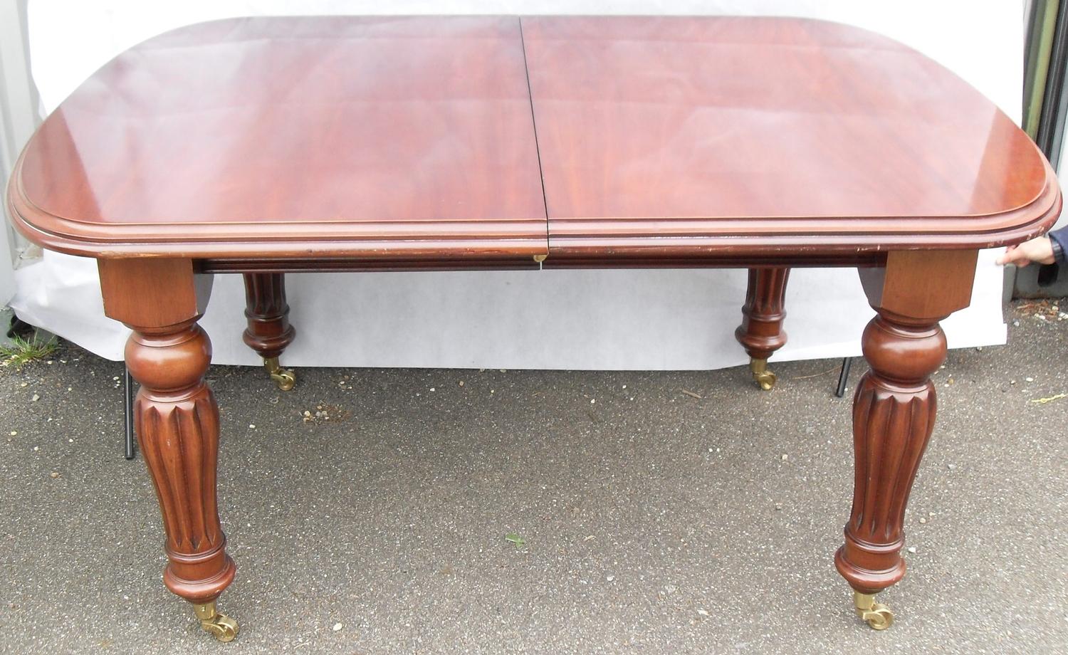 A Victorian-style mahogany pull-out extending dining table with two extra leaves on fluted