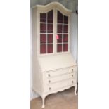 A dome-topped painted bureau bookcase in the Georgian style with twin glazed doors revealing a