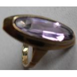 A stone set dress ring centering on an oval mixed-cut medium colour amethyst, measuring approx 19.