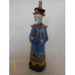 A Chinese richly coloured ceramic figurine of Han Xiangzi, one of the Eight Immortals, dressed in