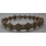 A gold and diamond bracelet comprising eighteen clusters of nineteen brilliant cut diamonds, (