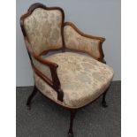 An Edwardian rosewood armchair with carved supports, fabric upholstery on cabriole legs and castors