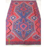 An Afgan hand-knotted herathi balouchi burgundy-ground wool rug with multicoloured isometric