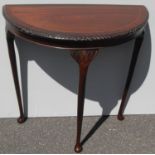 A Victorian-style oak and mahogany demi-lune table with carved rim, plain frieze on cabriole legs,