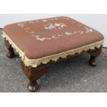 A Victorian oblong footstool with embroidered top raised on cabriole legs