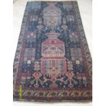 A hand-knotted multicoloured antique Persian rug with isometric designs, double border and short