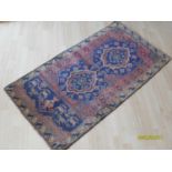 A hand-knotted antique multicoloured Persian wool rug with isometric designs, single border and