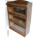 An early 20th century oak-stained, three-tier Lebus stacking or barrister bookcase with sliding