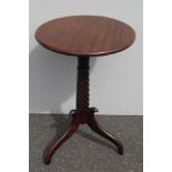 A William IV mahogany circular occasional table with carved fern decoration and rope-twist support