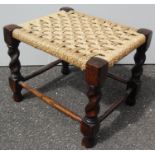 An oblong oak-framed rush woven footstool on rope twist legs and stretcher supports, 30 x 31 x 37 cm