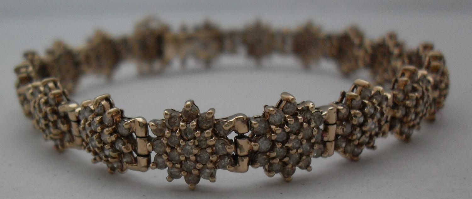 A gold and diamond bracelet comprising eighteen clusters of nineteen brilliant cut diamonds, ( - Image 4 of 5