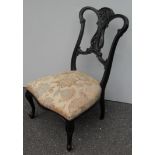 A Victorian lacquered low-sized occasional chair with elaborate carving to top rail and fret work to