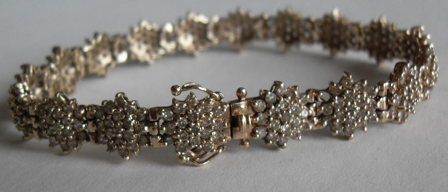 A gold and diamond bracelet comprising eighteen clusters of nineteen brilliant cut diamonds, (