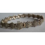 A gold and diamond bracelet comprising eighteen clusters of nineteen brilliant cut diamonds, (