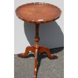 A Georgian-style walnut wine or occasional table with pie-crust rim, fluted support on a tripod