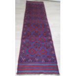 An Eastern hand-knotted Meshwani burgundy-ground wool runner with multicoloured isometric designs