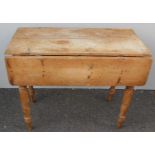 A 19th century pine Pembroke table with, two plank top, twin drop leaves, frieze drawer on turned