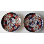 A pair of 19th century Japanese Imari plates with scalloped edges painted in underglaze blue and