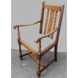 An early 20th century oak carver chair with carved splat and arms, fabric upholstered drop-in seat