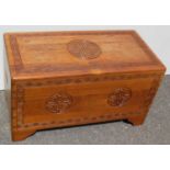 An early 20th century Chinese camphor wood chest with carved Tao medallions and Greek-key designs,