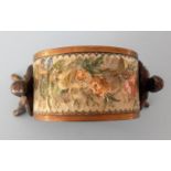 A bronze napkin holder with floral decoupage designs to outer ring supported by two folk dancers