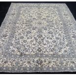 A Kashan hand-knotted ivory-ground wool drawing room rug with multi-coloured floral and foliate