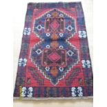An Afgan hand-knotted herathi balochi burgundy-ground rug with contrasting multicoloured designs,