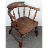 An early 19th century elm smoker's bow with carved arms, spindle supports, dished seat on turned