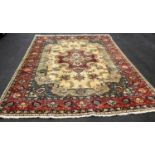 A Tabriz hand-knotted ivory-ground wool rug with multi-coloured floral and foliate designs, burgundy