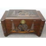 An Oriental camphorwood trunk with elaborate carving to top and front with interior sliding