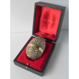 A Stuart Devlin hallmarked silver gilt limited edition novelty egg. The cover lifts to enclose a