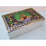 A champlevé decorated oblong white metal trinket box depicting a peacock in vitreous enamels to lid,